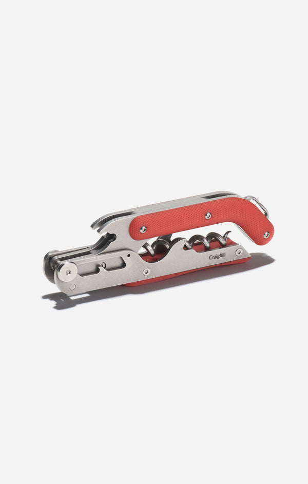 Corkscrew with red handle on a white background