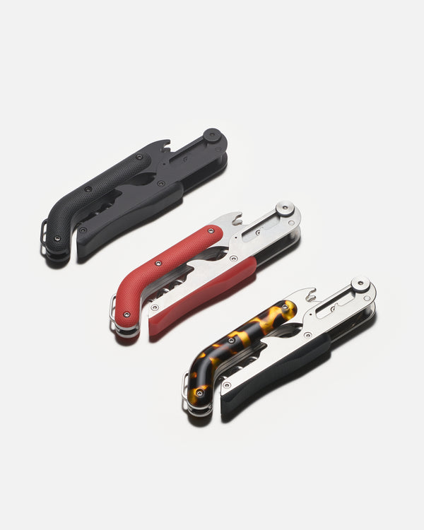 Three bottle openers in black, red, and tortoiseshell design on a white background