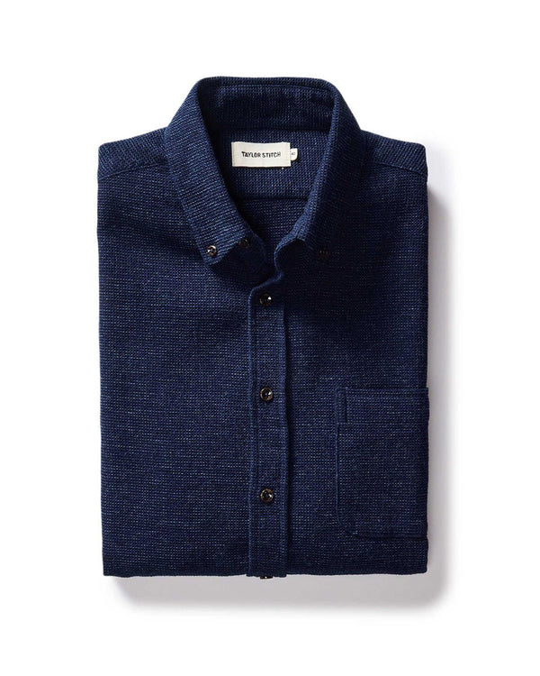 Folded navy blue shirt with a label on a white background