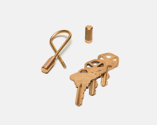Set of brass keys and keychain on a white background