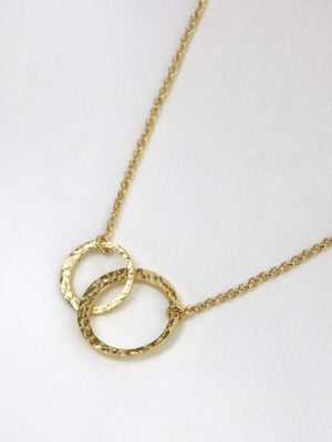 Gold necklace with interlocking rings on a white background