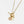 Gold necklace with a pink stone and tag on a white background