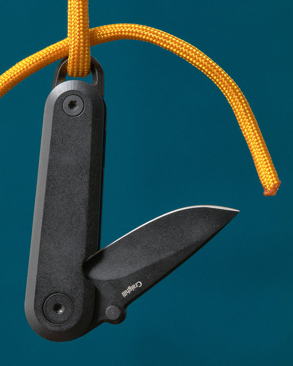 Black folding knife with a yellow rope on a blue background