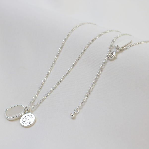 Silver necklace with pendant and clasp shown on a light gray background