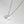Silver necklace with two round pendants on a light gray background