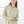 Woman wearing a light green button-up shirt in a bright room.