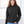 Person wearing a black hoodie and blue jeans indoors with a window in the background