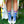 Person wearing colorful socks with a blue peacock pattern on grass