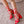 Red high-heeled shoes with heart and strawberry pattern on a textured surface