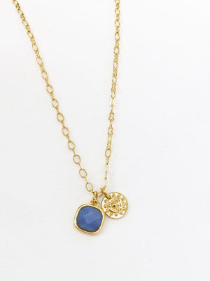 Gold necklace with a blue pendant on a white background