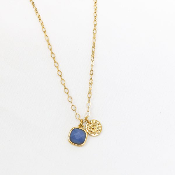 Gold necklace with a blue pendant on a white background