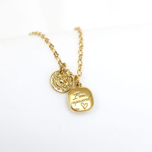 Gold necklace with two charms one engraved with 'I'm empowered' on a white background