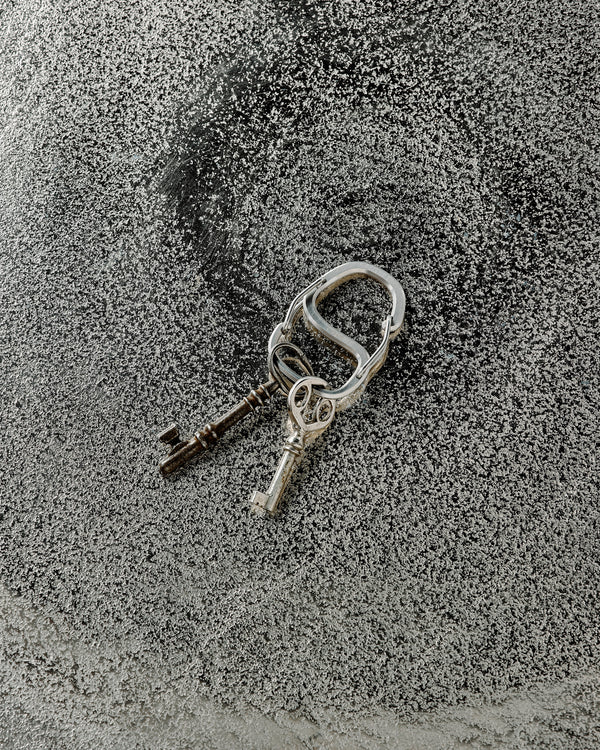 Two keys on a keychain on a textured surface