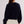 Person wearing a navy sweater and white skirt on a plain background