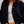 Person wearing a navy blue cardigan over a white top and skirt on a plain background