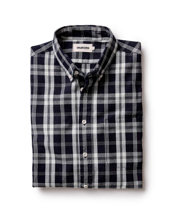 Folded dark navy and white checkered shirt on a white background