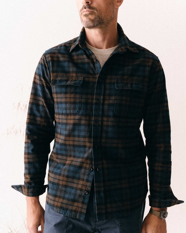 Man wearing a plaid shirt with a neutral background