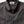 Close-up of a dark green and gray checkered shirt with 'Taylor Stitch' label on a white background